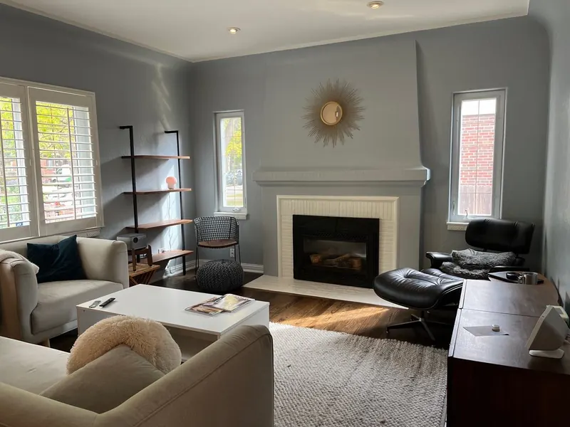 Repainted living room in slate blue-gray with white fireplace surround