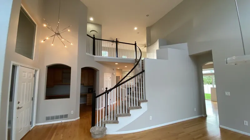 Repainted two-story entry with curved staircase in soft gray