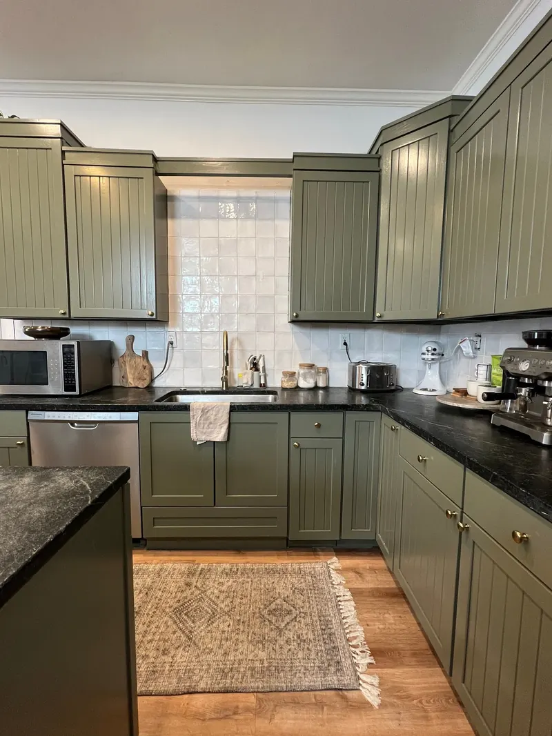 Repainted olive green kitchen cabinets with quartz island