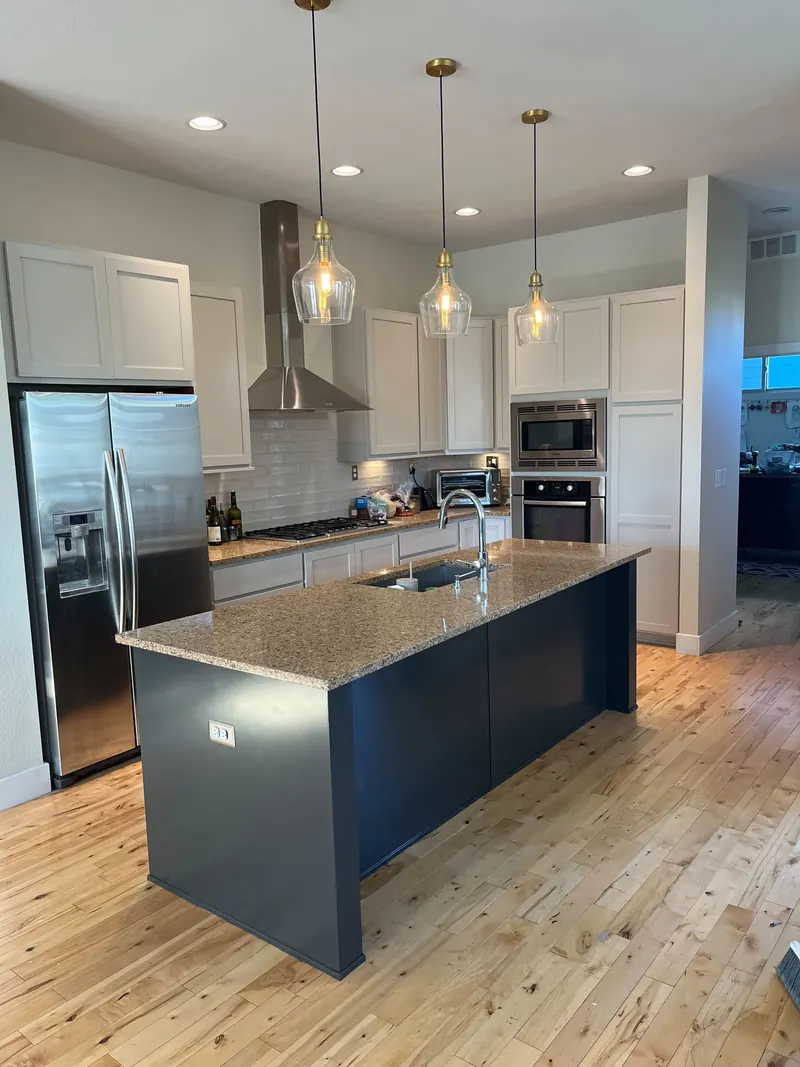 Repainted white kitchen cabinets with navy blue island